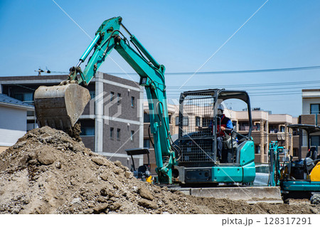 小型ショベルカーで住宅地の造成作業をする作業員 128317291