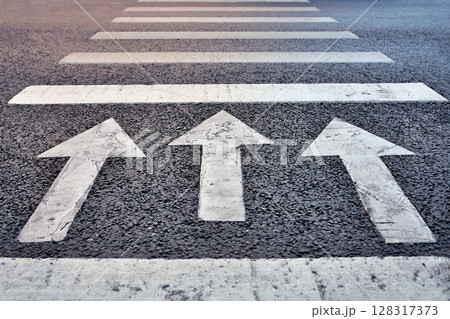 Three arrows on asphalt point forward a powerful symbol of purpose, progress, and moving ahead with clarity and determination. Three arrows on asphalt point forward a powerful symbol of purpose, progress, and moving ahead with clarity and determination. 128317373