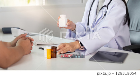 Doctor explaining medication options to patient during consultation in clinic. Doctor explaining medication options to patient during consultation in clinic. 128318054