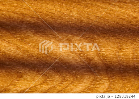 Close-up showcases a smooth, polished wood surface featuring intricate grain patterns 128319244