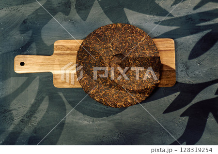 Discovering the rich texture and aroma of puer tea on a wooden board in a serene setting Discovering the rich texture and aroma of puer tea on a wooden board in a serene setting 128319254