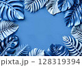 Tropical leaves frame on blue background with copy space 128319394