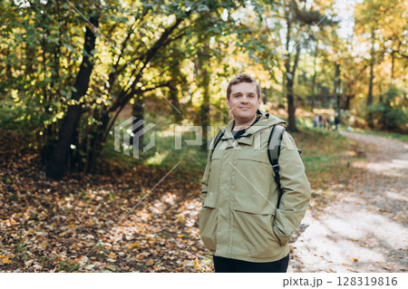 Calm happy 30s Man Relaxing in Autumn Park Outdoors. Traveler. Falling time. Smiling man in casual clothing standing outdoor 128319816