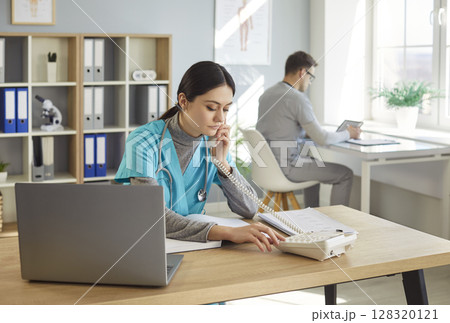 Telephone consultation, health care therapist worker at laptop online, clinic staff assistant Telephone consultation, health care therapist worker at laptop online, clinic staff assistant 128320121