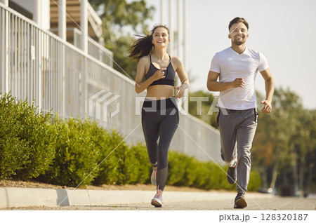 Young couple running together in city park having sport workout outdoors. Young couple running together in city park having sport workout outdoors. 128320187