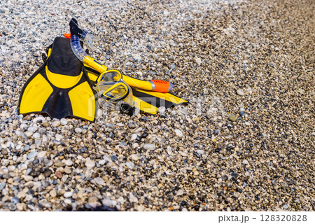 Flippers and snorkeling tube on sea shore Flippers and snorkeling tube on sea shore 128320828