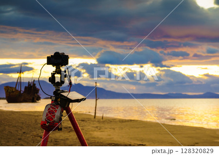 Camera on tripod and shipwreck Camera on tripod and shipwreck 128320829