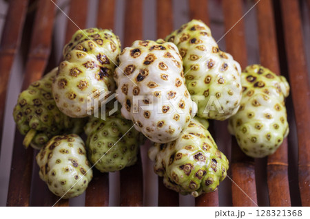 Exotic Noni Fruits Beautifully Arranged on a Rustic Wooden Surface for an Appealing Look 128321368