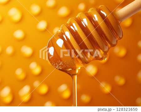 Honey dripping in a beautiful golden background with sweet natural organic syrup Honey dripping in a beautiful golden background with sweet natural organic syrup 128321650