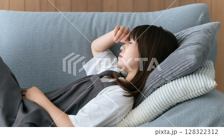 疲れてソファに寝転ぶ女性 128322312