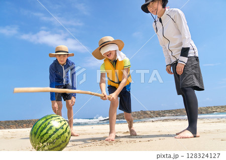 夏の海辺でスイカ割りを楽しむ家族のレジャーシーン 128324127