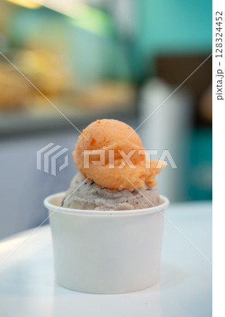A cup of Gelato, Banana choc chip and tomato Ice-cream on the table with blur background. 128324452