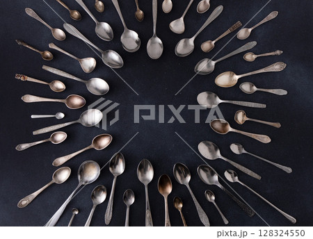 Set of different spoons. Silver cutlery on a black background. Spoon on the table Set of different spoons. Silver cutlery on a black background. Spoon on the table 128324550
