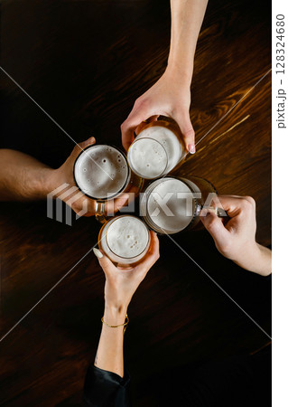 Four people toasting with beer mugs from top view. 128324680