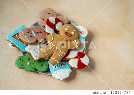 Gingerbread cookies with icing decoration. Christmas food. Gingerbread man baking. Top view table. Xmas sweet on biege background Gingerbread cookies with icing decoration. Christmas food. Gingerbread man baking. Top view table. Xmas sweet on biege background 128324784