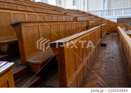 Rows of Wooden Benches in Lecture Hall. University auditorium classroom 128324884