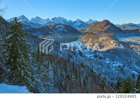 Beautiful winter morning landscape with snowy mountains and a serene lake, icy landscape surrounding majestic peaks, dawn light in January Beautiful winter morning landscape with snowy mountains and a serene lake, icy landscape surrounding majestic peaks, dawn light in January 128324885