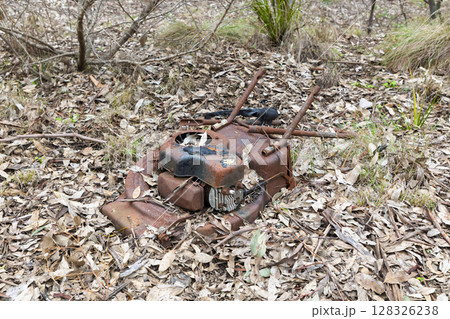 An old rusty lawn mower abandoned in a forest An old rusty lawn mower abandoned in a forest 128326238