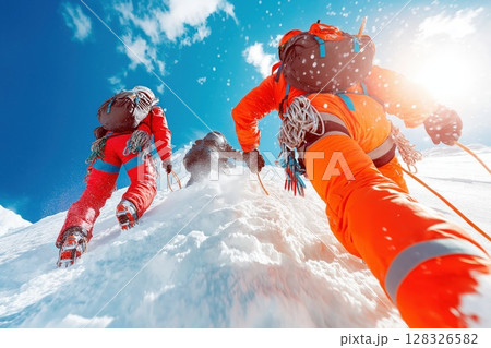 Mountain rescue team climbs snowy slope with ropes and harnesses during bright day 128326582