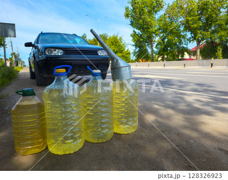 car stopped in front of by plastic bottles with gasoline on the side of the road 128326923