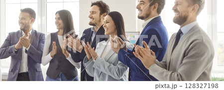 Smiling group of business professionals applauding, celebrating success during meeting in office. 128327198