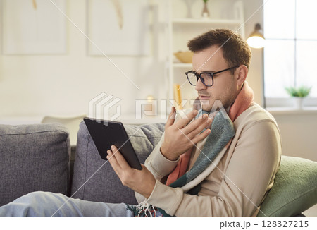 Sick man gets online consultancy with doctor via digital tablet 128327215