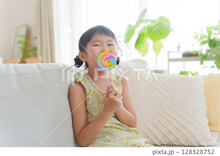 お菓子の飴を食べる子供 128328752