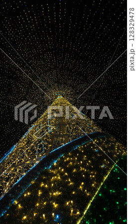 Stunning Upward View of a Beautifully Decorated Christmas Tree Illuminated with Twinkling Lights Creating a Magical Festive Atmosphere 128329478