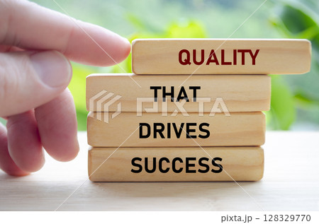 Quality that drives success text on wooden blocks being pushed forward symbolizes how excellence leads to real achievement Quality that drives success text on wooden blocks being pushed forward symbolizes how excellence leads to real achievement 128329770