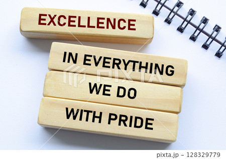 Excellence in everything we do with pride text on wooden blocks and notebook reflects unwavering quality and pride in every action Excellence in everything we do with pride text on wooden blocks and notebook reflects unwavering quality and pride in every action 128329779