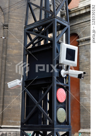Traffic Signal Pole with Surveillance Cameras and Lights in an Urban Setting, Emphasizing Road Safety and Technology Integration in Modern City Infrastructure Traffic Signal Pole with Surveillance Cameras and Lights in an Urban Setting, Emphasizing Road Safety and Technology Integration in Modern City Infrastructure 128330192