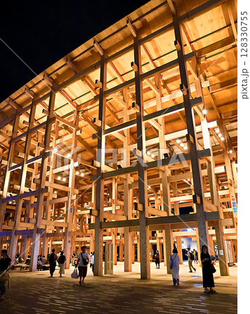 大阪　関西万博　ライトアップされた大屋根リングの下を歩く人々 128330755