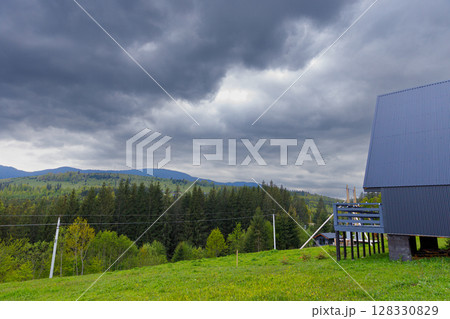 A Serene Mountain Landscape Under Ominous Clouds Capturing Nature's Beauty and Intensity on a Tranquil Day in the Countryside 128330829