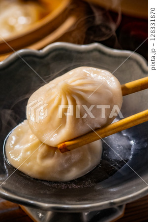 Delicious Soup Dumpling Held with Chopsticks. 128331870