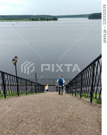 A modern staircase descends to the riverfront, a vertical 128332039