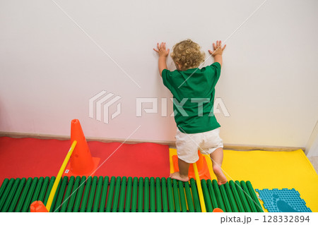 child walking up vertical fitness stairs in kindergarten gym child walking up vertical fitness stairs in kindergarten gym 128332894