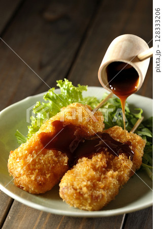 敷いた野菜とソースがかかった串カツ 128333206