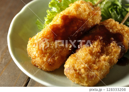 敷いた野菜とソースがかかった串カツ 128333208