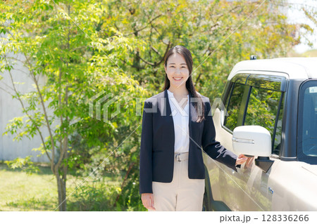 車の横に立つスーツの女性 車の横に立つスーツの女性 128336266