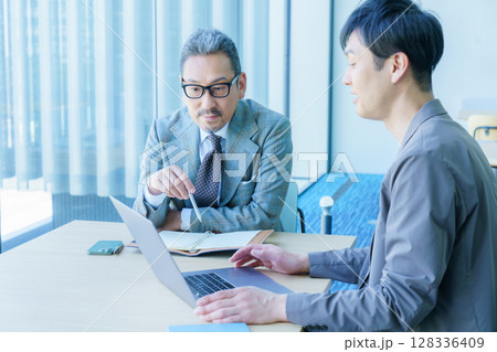 打ち合わせをするミドルエイジのビジネスマン2人　撮影協力:スカパー東京メディアセンター 128336409