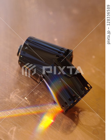 Black roll of film is sitting on a table Black roll of film is sitting on a table 128336589