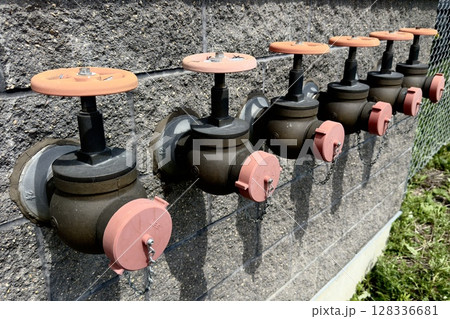 industrial valves with handles on the wall 128336681
