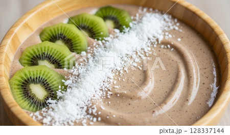 Smoothie Bowl with Kiwi Fruit Slices and Coconut Shavings in Wooden Bowl Smoothie Bowl with Kiwi Fruit Slices and Coconut Shavings in Wooden Bowl 128337144