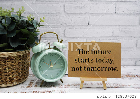 The future starts to day, not tomorrow text message with easel stand on wooden background The future starts to day, not tomorrow text message with easel stand on wooden background 128337628