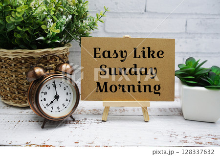 Enjoy like Sunday Morning text message with easel stand on wooden background Enjoy like Sunday Morning text message with easel stand on wooden background 128337632