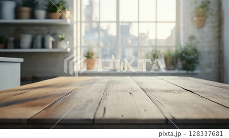 close-up of a wooden table in front of a window. The table is empty and the background is blurred, but it appears to be a kitchen or living room with white walls	 128337681