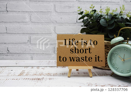 Life is to short to waste it text message with easel stand on wooden background 128337706