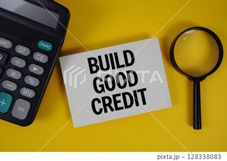 Build Good Credit text with magnifying glass anc calculator on yellow background Build Good Credit text with magnifying glass anc calculator on yellow background 128338083