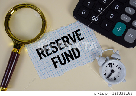 Reserve Fund text with alarm clock, magnifying glass anc calculator on yellow background 128338163