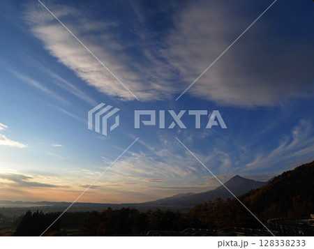 日没後、シルエットの磐梯山上空に広がる白い雲とオレンジ色の夕焼けが印象的で綺麗だ。 128338233